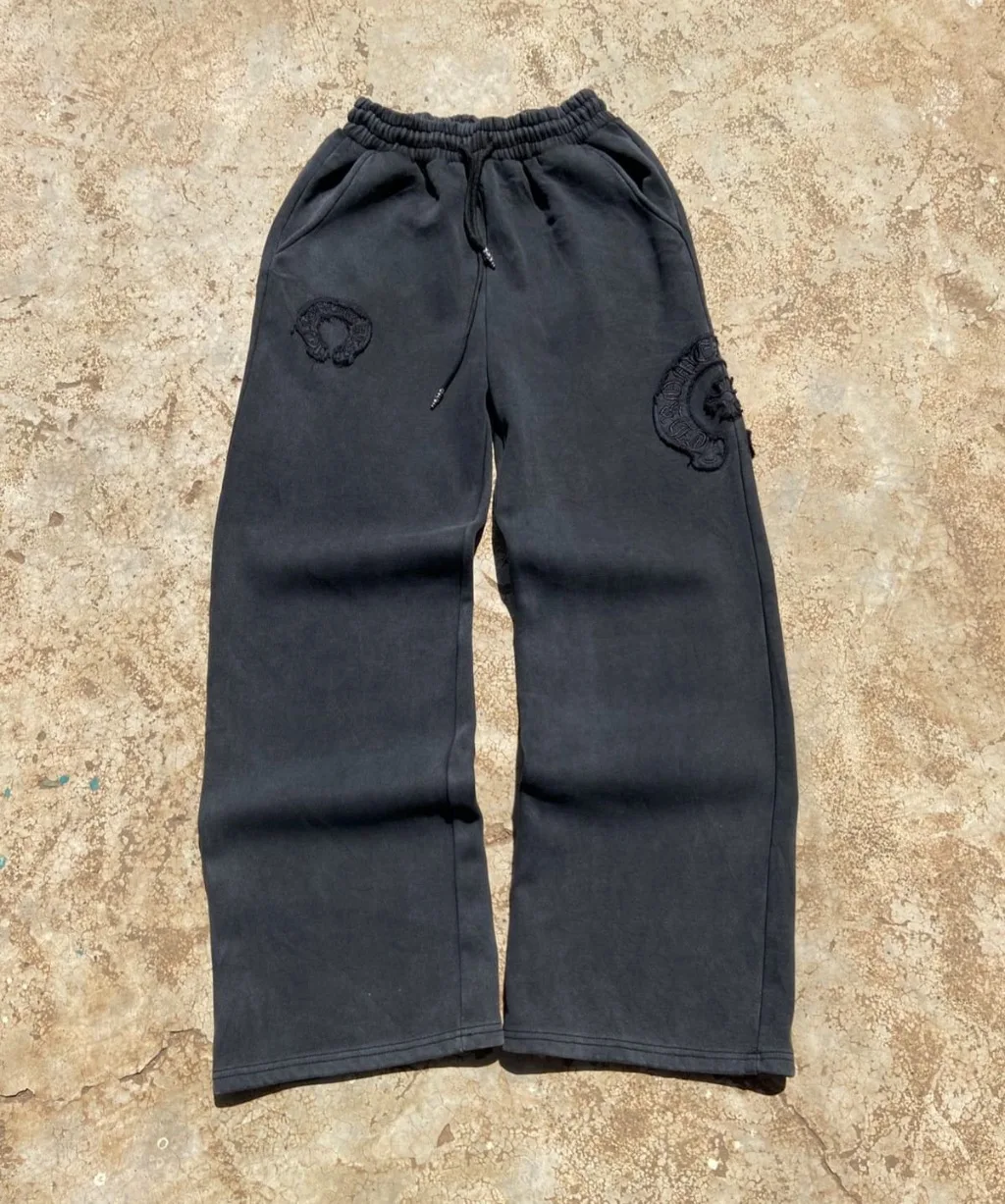 Black faded wide-leg sweatpants with tonal embroidered patches.