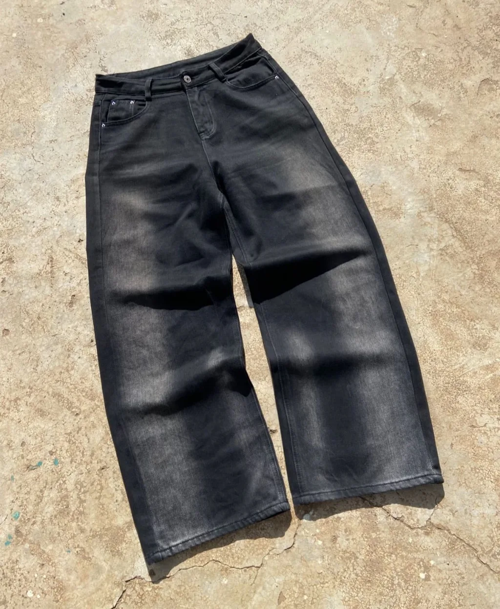 Faded black wide-leg baggy jeans with sun-fade wash.