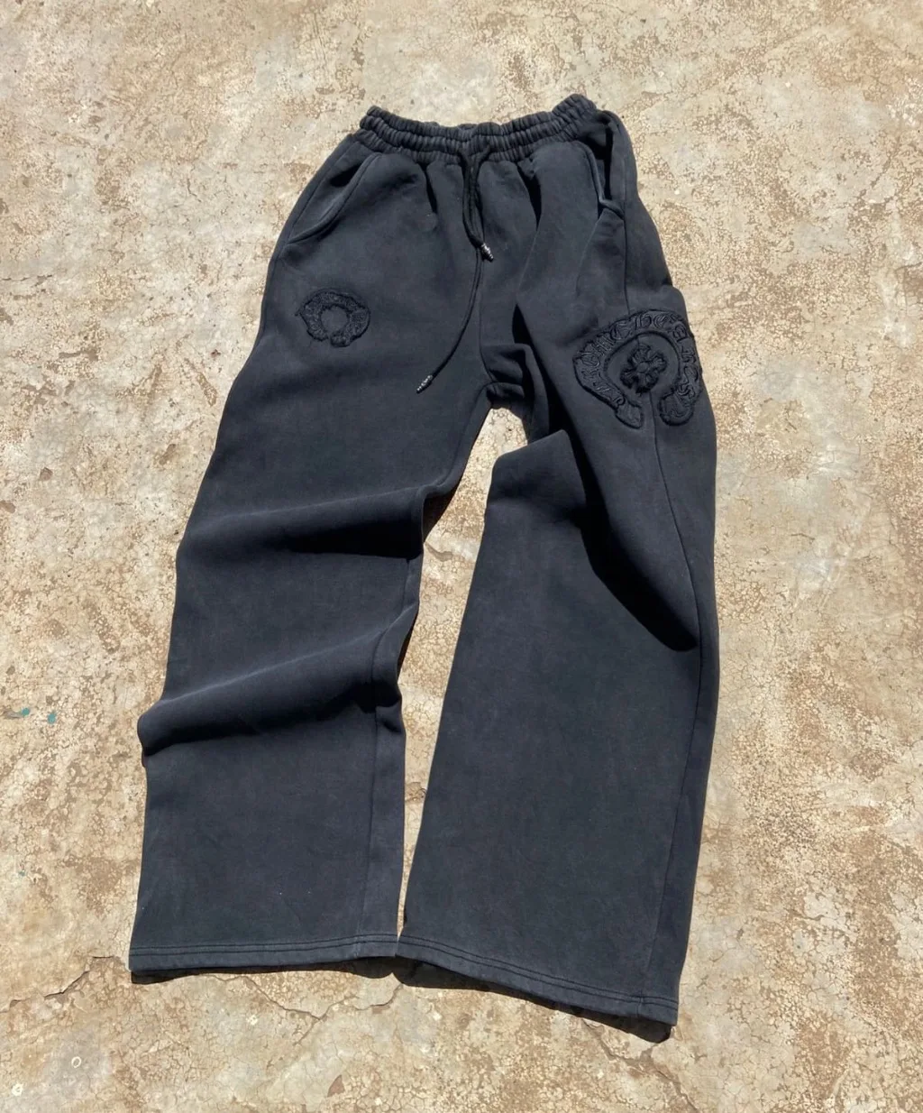 Black faded wide-leg sweatpants with tonal embroidered patches.