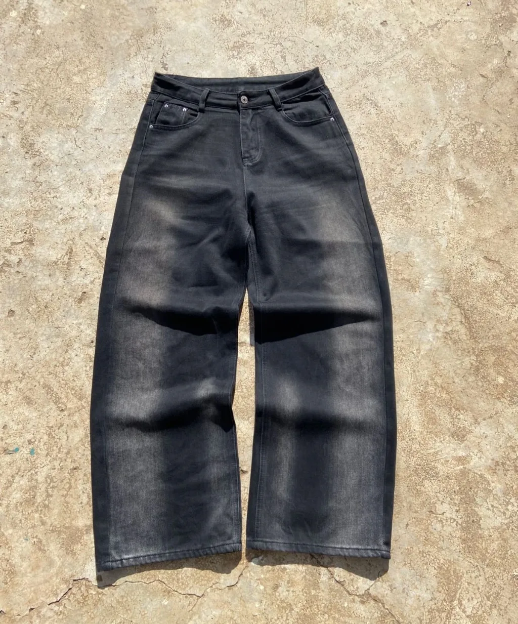 Faded black wide-leg baggy jeans with sun-fade wash.