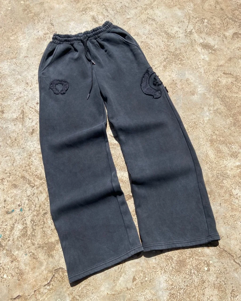 Black faded wide-leg sweatpants with tonal embroidered patches.