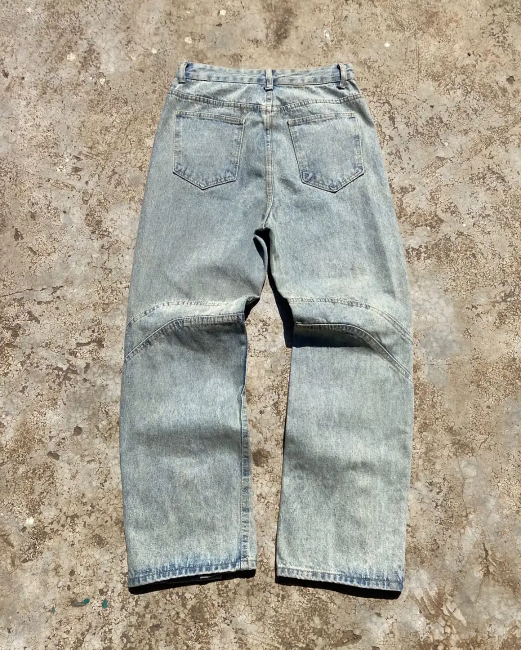 Light wash wide-leg denim jeans with panelled design and snap button hem.